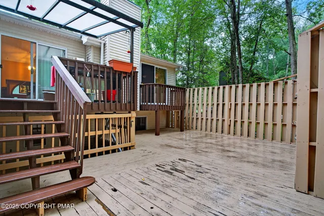 a balcony with wooden floor stairs and wooden fence