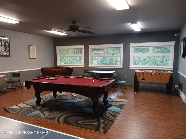 a room with furniture pool table and windows