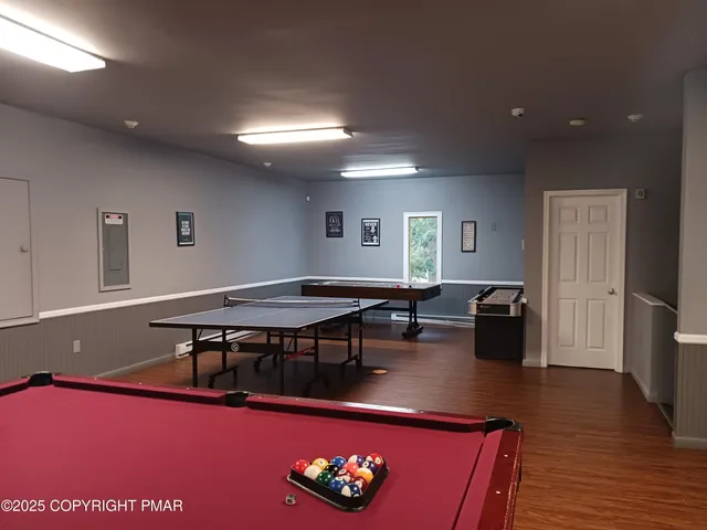 a living room with furniture pool table and a wooden floor
