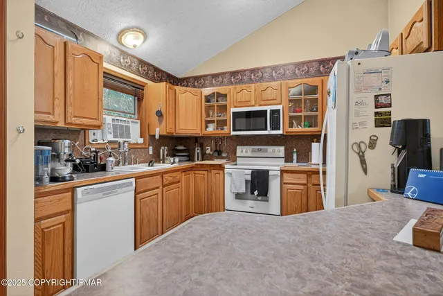 a kitchen with stainless steel appliances kitchen island granite countertop a refrigerator and a stove top oven