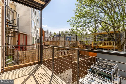a view of a balcony with wooden floor and fence and a floor to ceiling window
