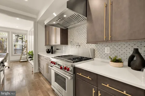 a kitchen with a sink a stove and cabinets