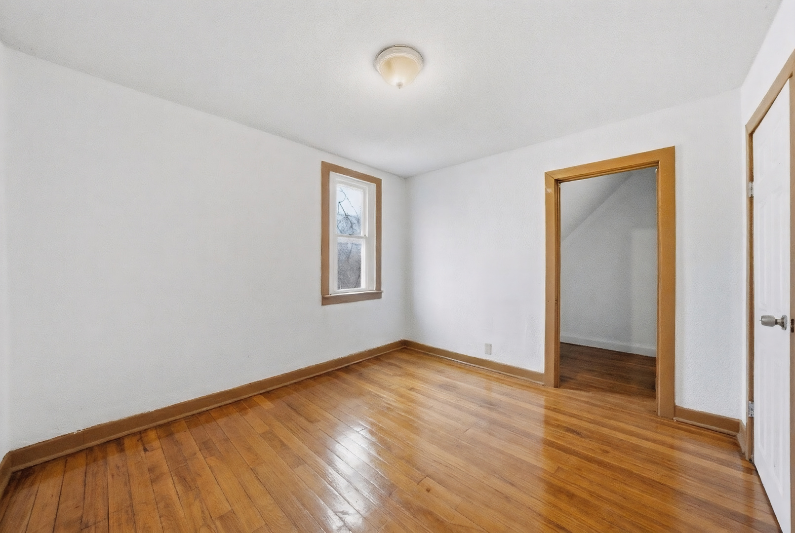 11735 South Indiana Avenue Chicago, IL 60628 - Photo 11 of 26 an empty room with wooden floor and windows