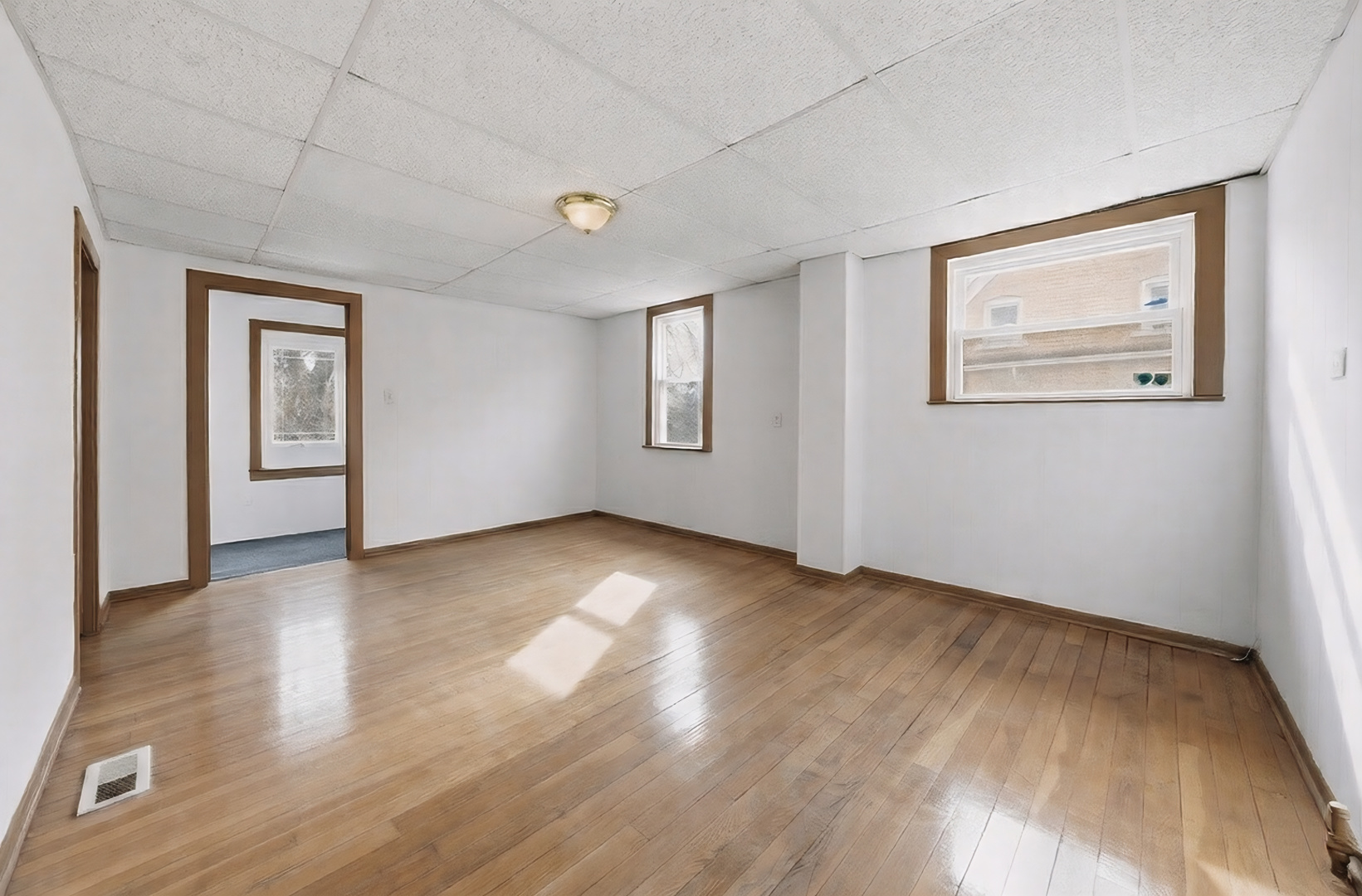 11735 South Indiana Avenue Chicago, IL 60628 - Photo 12 of 26 a view of an empty room with window and wooden floor