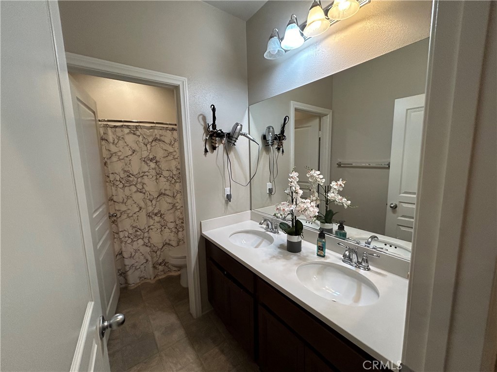 30099 Whembly Circle Menifee, CA 92584 - Photo 23 of 42 a bathroom with a sink double vanity and a mirror