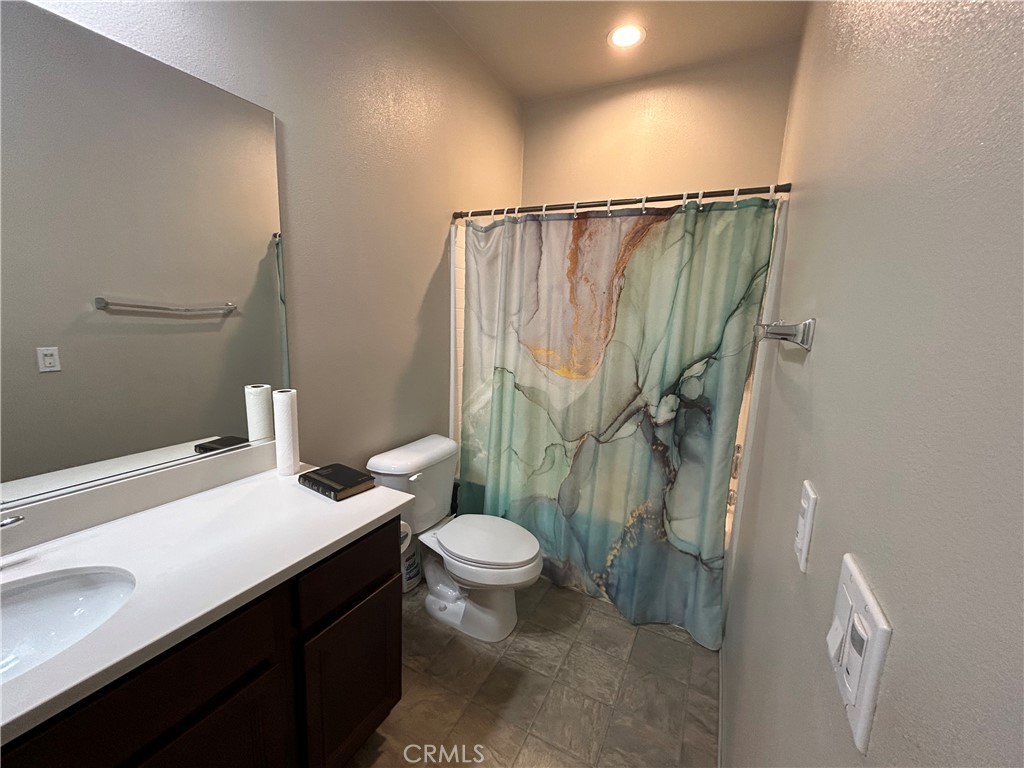 30099 Whembly Circle Menifee, CA 92584 - Photo 27 of 42 a bathroom with a sink a toilet a mirror and shower