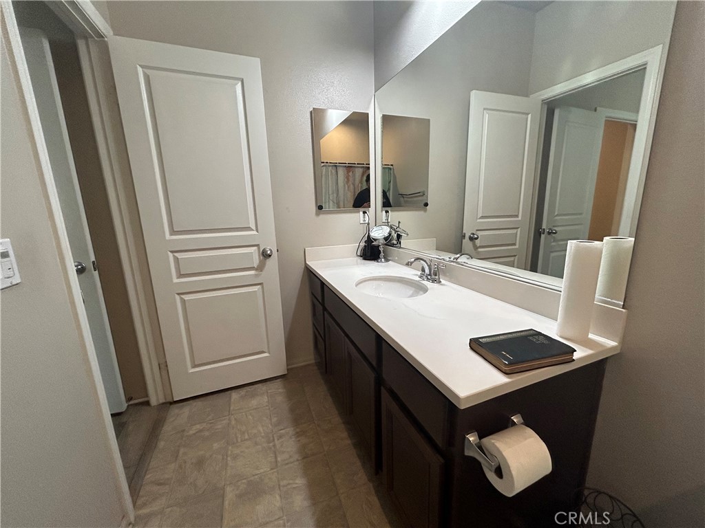 30099 Whembly Circle Menifee, CA 92584 - Photo 28 of 42 a bathroom with a sink vanity and a mirror