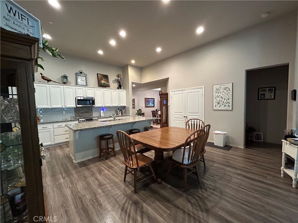 30099 Whembly Circle Menifee, CA 92584 - Photo 8 of 42 a open dining room with stainless steel appliances kitchen island granite countertop a dining table chairs and a refrigerator