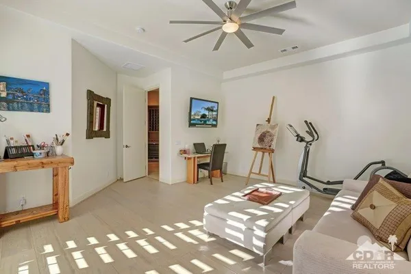a living room with furniture a flat screen tv and a dresser