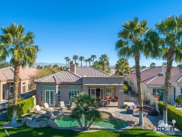 a front view of a house with garden and trees
