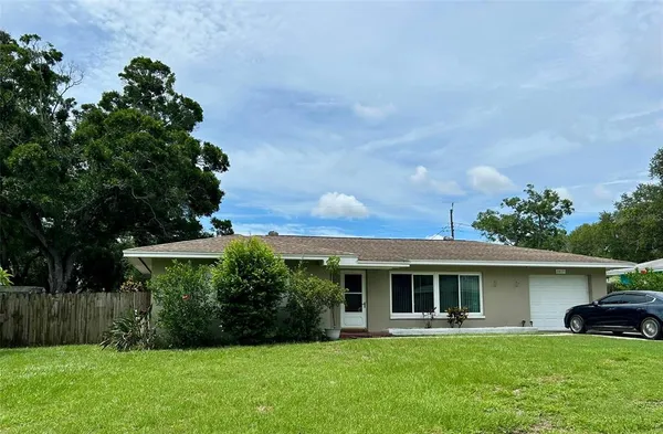 a view of a house with a yard and potted plants