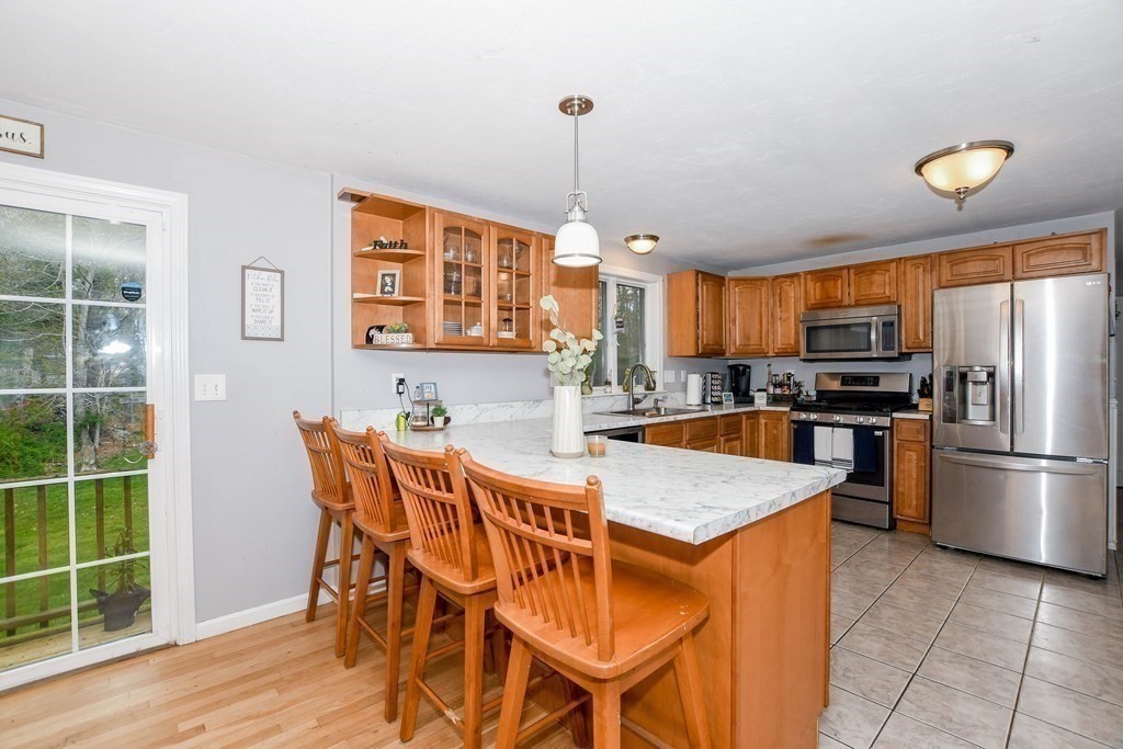 116 Tispaquin Street Middleboro, MA 02346 - Photo 6 of 37 a kitchen with stainless steel appliances granite countertop a stove top oven a sink dishwasher a dining table and chairs with wooden floor