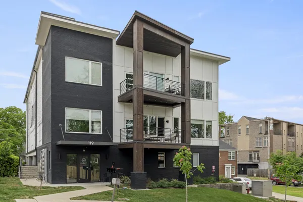 a front view of a residential apartment building with a yard