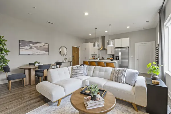 a living room with furniture kitchen and a table