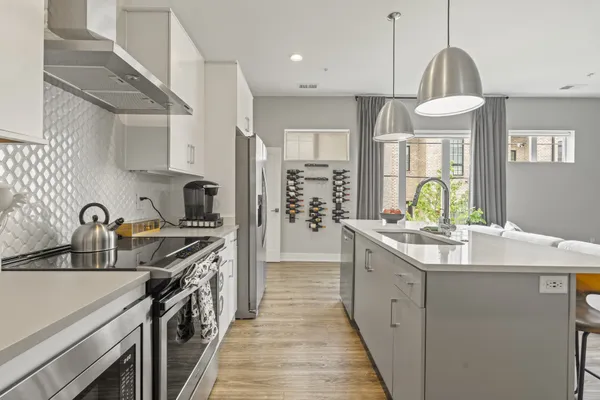 a kitchen with stainless steel appliances a sink stove and cabinets