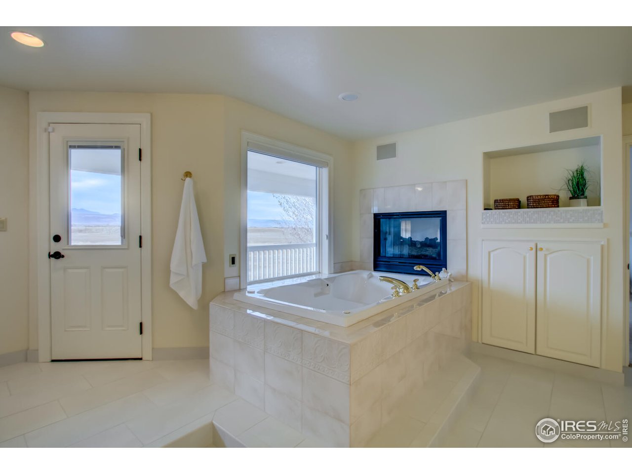 7401 Deerfield Road Longmont, CO 80503 - Photo 27 of 39 Soaking tub with views and fireplace