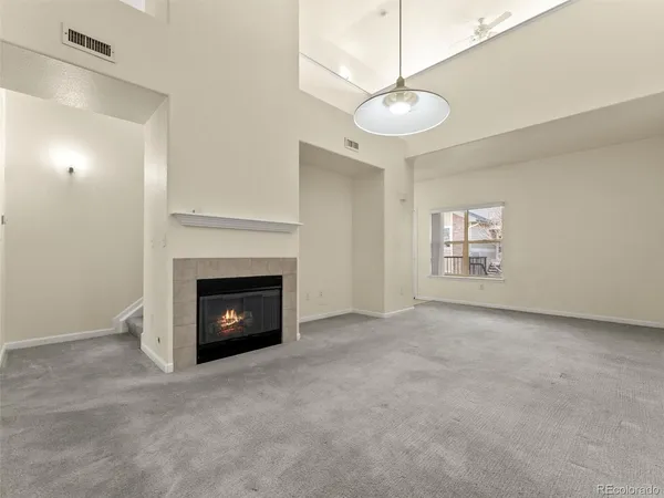 a view of an empty room with a fireplace and a window