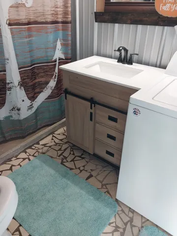 a room with lots of white furniture and shower