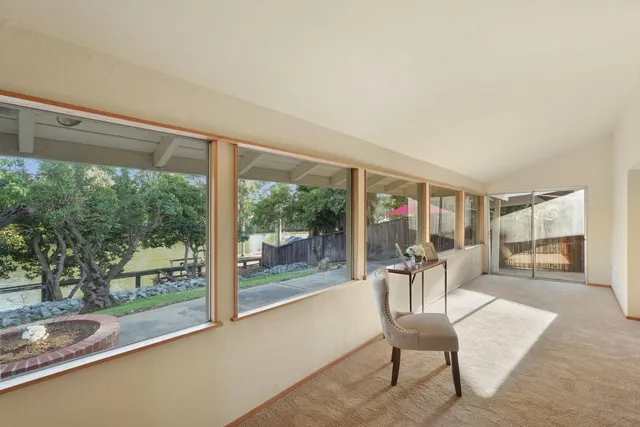 a dining room with furniture water view and a floor to ceiling window