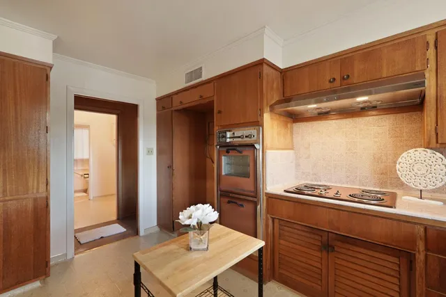 a kitchen with a refrigerator and a stove top oven