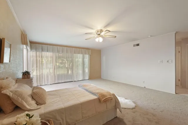 a bedroom with a large bed and a chandelier