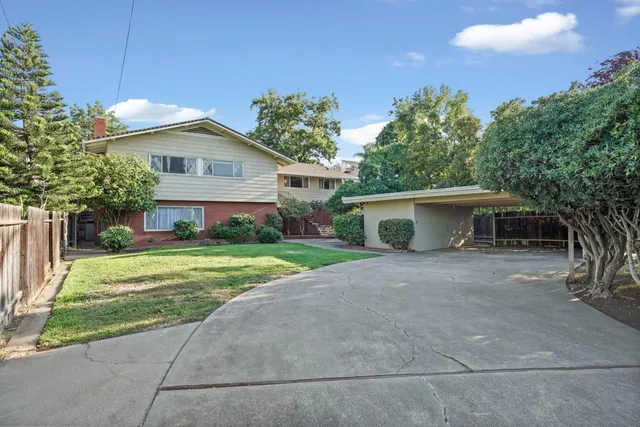 a front view of a house with a yard and trees