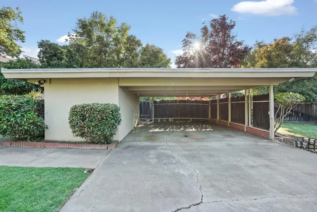 a view of a house with a yard and potted plants