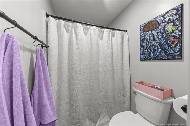 a white toilet sitting next to a shower curtain