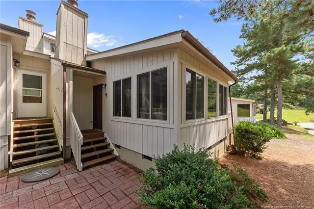 a front view of a house with stairs and a yard