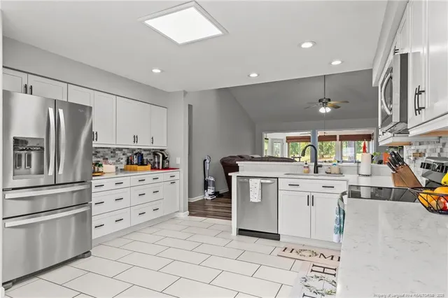 a kitchen with white cabinets and stainless steel appliances