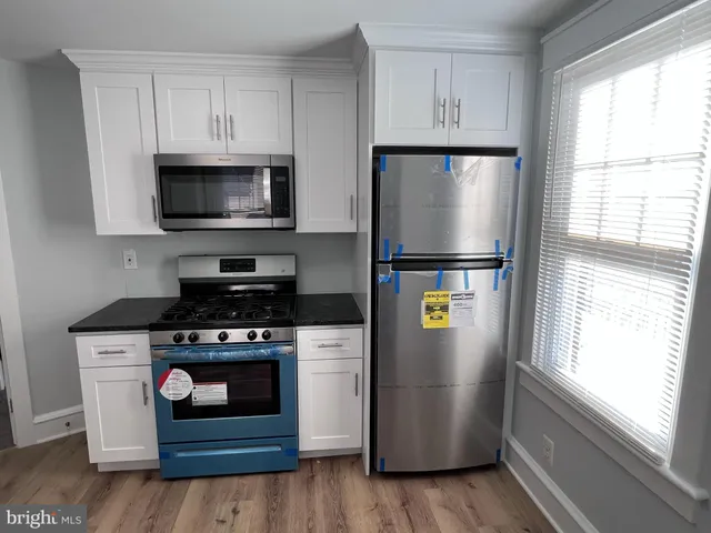 a kitchen with stainless steel appliances a refrigerator stove and microwave