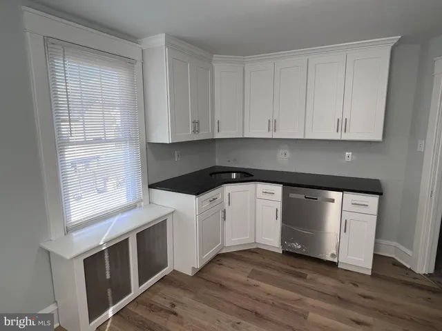 a kitchen with granite countertop white cabinets and black appliances
