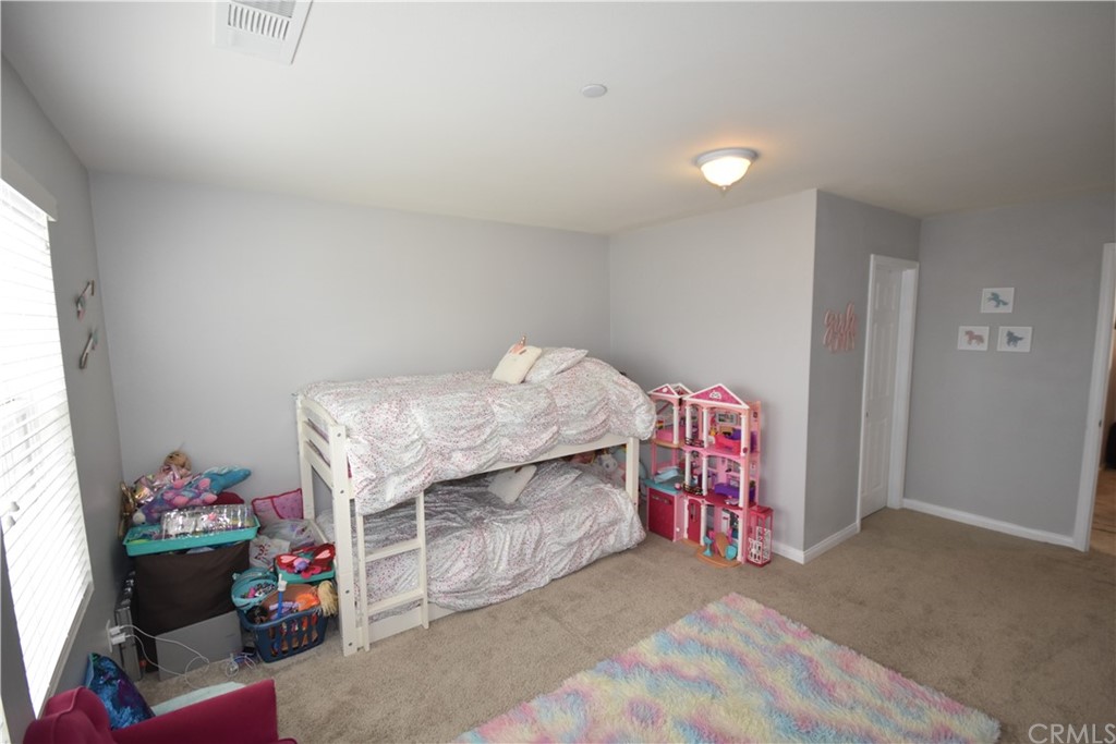 581 Poo'ish Avenue San Jacinto, CA 92582 - Photo 26 of 32 a bedroom with a bed and a chandelier