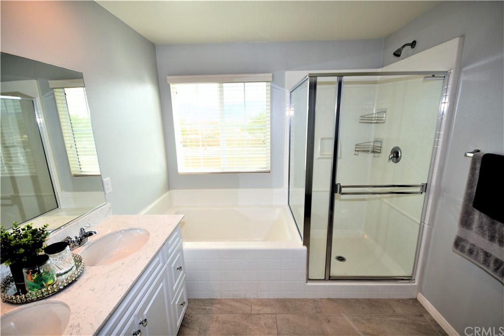 581 Poo'ish Avenue San Jacinto, CA 92582 - Photo 30 of 32 a bathroom with a tub sink and mirror