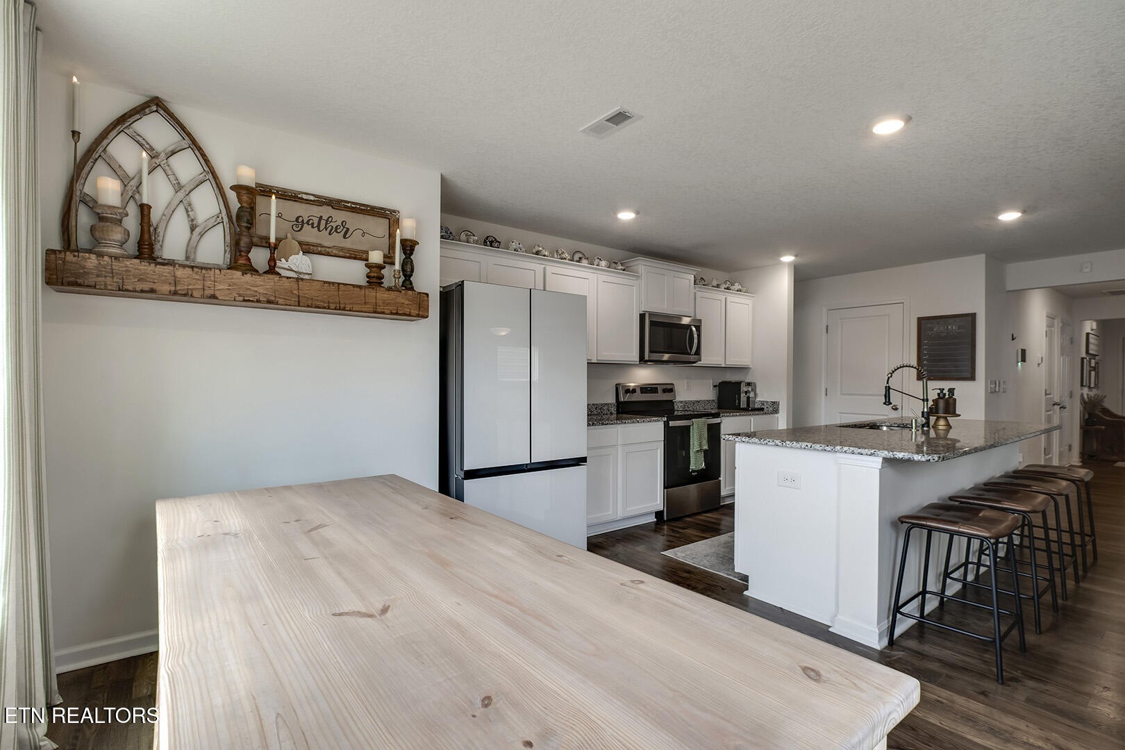 7519 Game Bird Street Corryton, TN 37721 - Photo 11 of 50 a kitchen with stainless steel appliances kitchen island granite countertop a refrigerator oven a sink dishwasher and a dining table with wooden floor