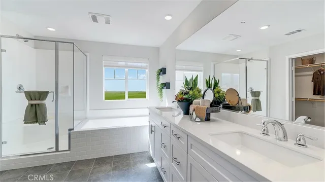 a bathroom with a double vanity sink a mirror and a bathtub