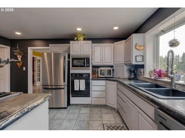 a kitchen with kitchen island granite countertop white cabinets and refrigerator