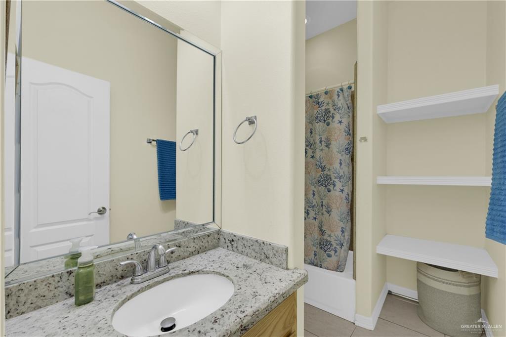 305 North 15th Street Hidalgo, TX 78557 - Photo 19 of 28 a bathroom with a granite countertop sink a toilet and shower