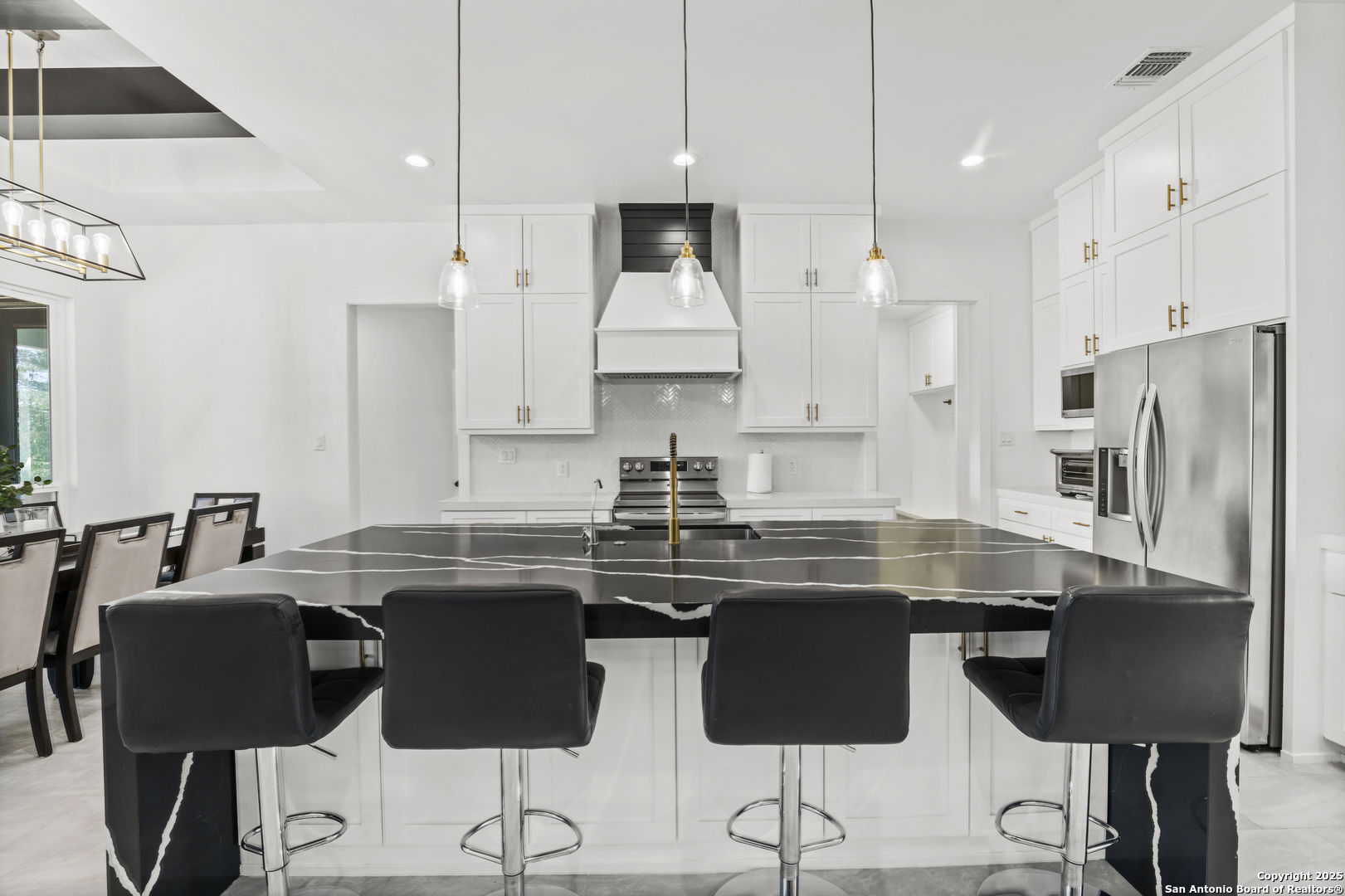 1101 Persimmon Pass Fischer, TX 78623 - Photo 13 of 43 a kitchen with stainless steel appliances granite countertop a stove a refrigerator a sink a dining table and chairs with wooden floor