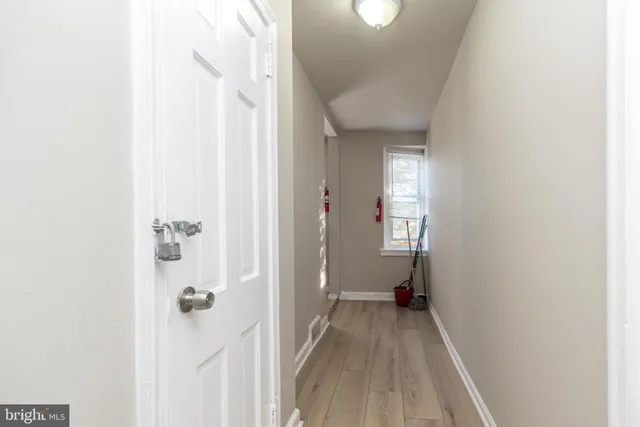 a view of a room with wooden floor and a bathroom