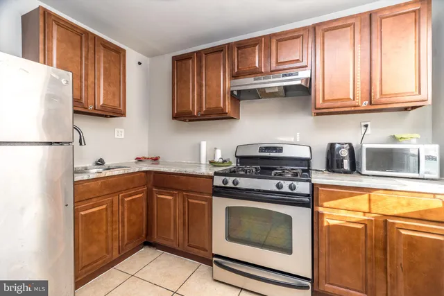a kitchen with stainless steel appliances granite countertop a stove sink and cabinets