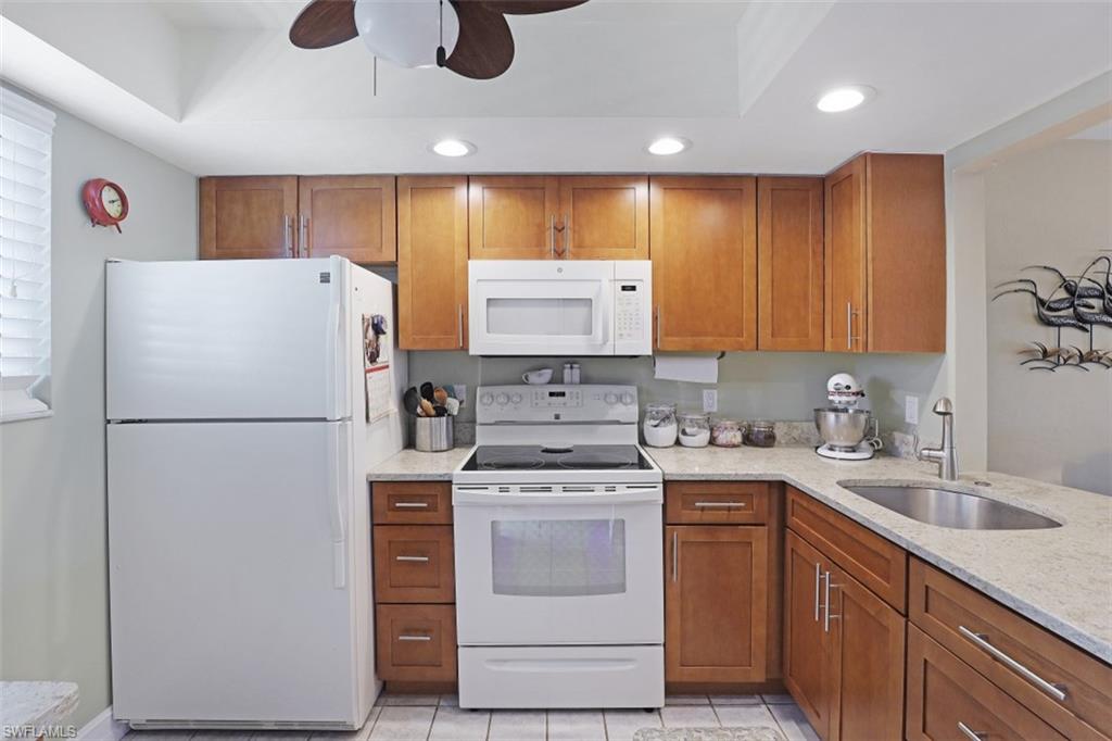 1004 Manatee Road, Unit H301 Naples, FL 34114 - Photo 12 of 33 a white refrigerator freezer sitting inside of a kitchen