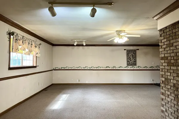 an empty room with windows and fireplace