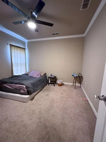 a room with a bed and a ceiling fan
