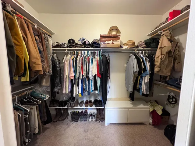 a view of walk in closet with clothes and shoes