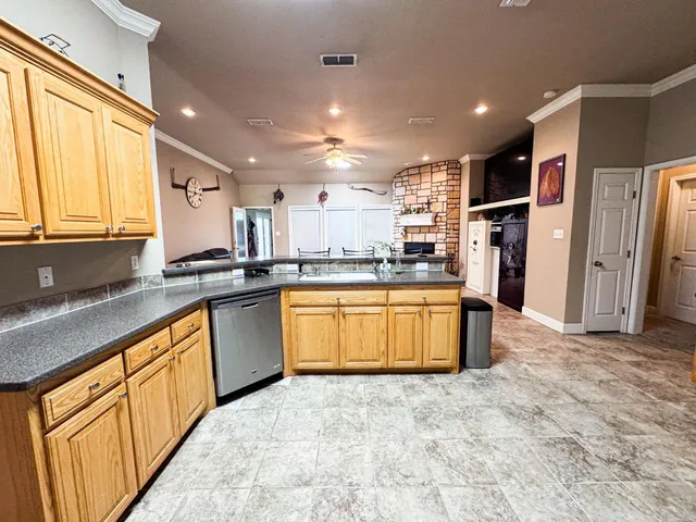 a large kitchen with stainless steel appliances kitchen island granite countertop a refrigerator sink and cabinets