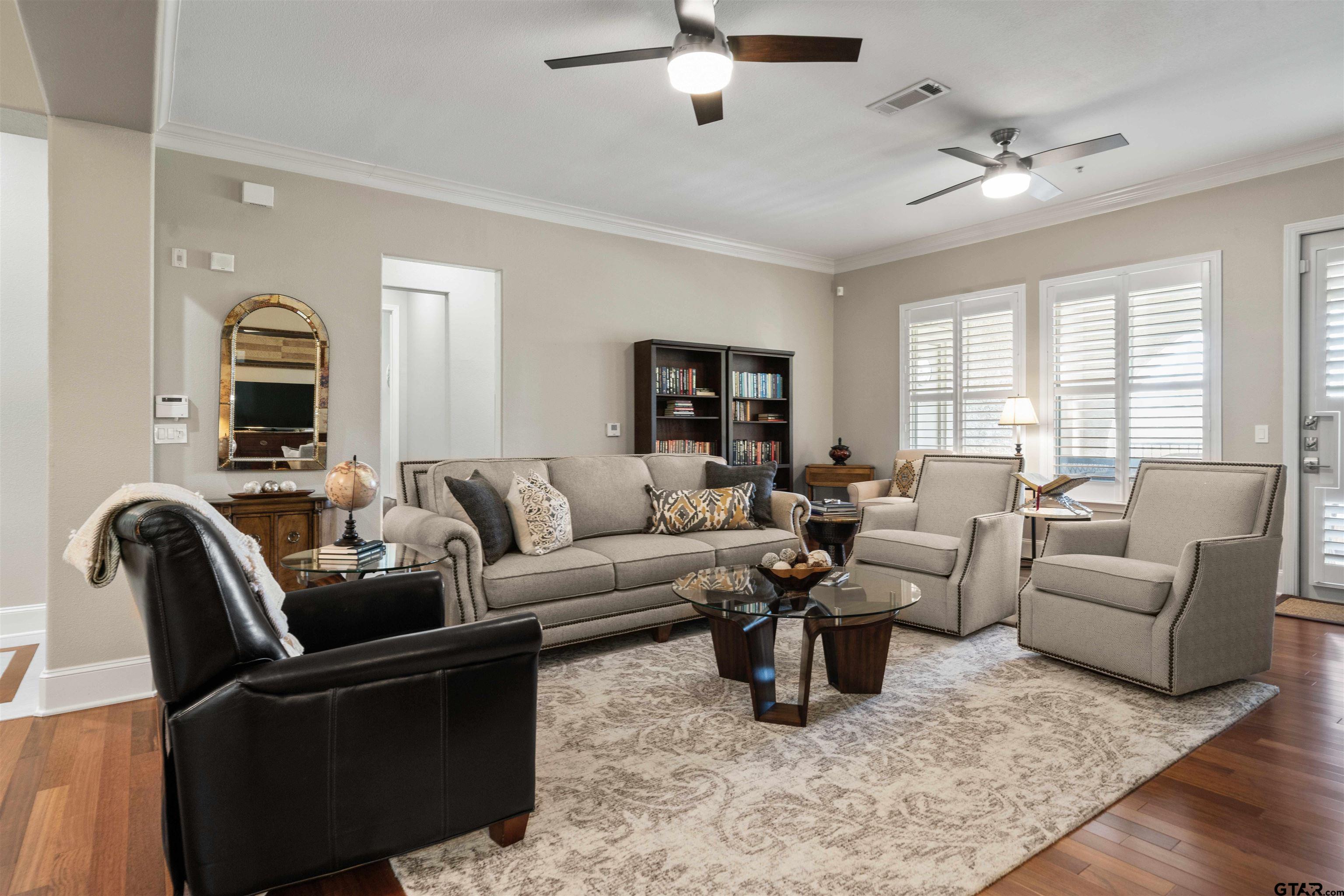 a living room with furniture ceiling fan and a window