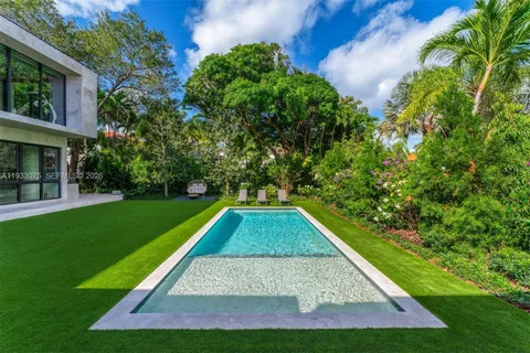 a view of pool with lawn chairs and a big yard