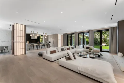 a living room with furniture flat screen tv and a large window