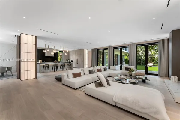 a living room with furniture flat screen tv and a large window